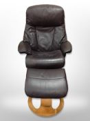 A Scandinavian brown leather swivel armchair and matching footstool