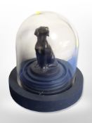 A contemporary bronzed figure of a seated dog under glass dome,