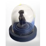 A contemporary bronzed figure of a seated dog under glass dome,