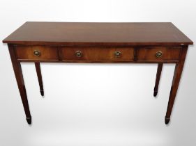 A reproduction mahogany three drawer side table,