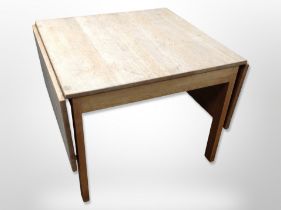 A 20th century Danish blond oak drop leaf coffee table,