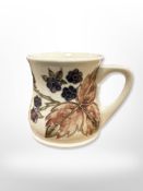 A Moorcroft mug decorated with blackberries, height 8.