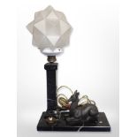 An Art Deco marble and frosted glass table lamp surmounted by a recumbent deer,