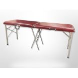 An aluminium and red vinyl foldng massage table