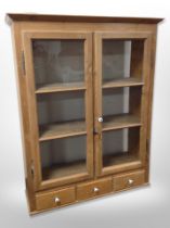 A glazed pine cabinet,