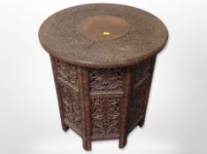 An Anglo Indian heavily carved hardwood circular octagonal occasional table,