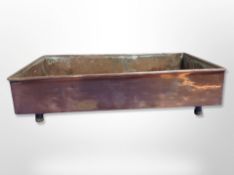 A 19th century copper plant pot tray on raised legs,