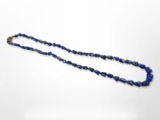 A lapis lazuli bead necklace with silver-gilt clasp,