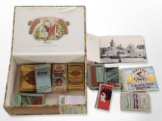 A cigar box containing cigarette cards,