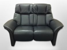 A contemporary black stitched leather two seater settee,