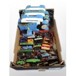 A group of Thomas the Tank Engine locomotives and carriages, in plastic boxes.