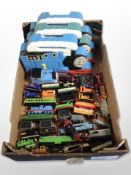 A group of Thomas the Tank Engine locomotives and carriages, in plastic boxes.