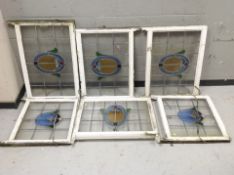 Six early 20th-century leaded glass windows in painted frames, largest 90cm x 68cm overall.