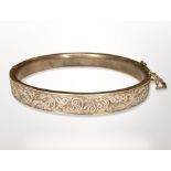 An antique engraved gold hinged bangle, apparently unmarked, inner diameter 5.