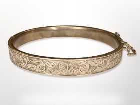 An antique engraved gold hinged bangle, apparently unmarked, inner diameter 5.