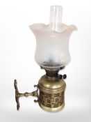 A brass Duplex wall-mounted oil lamp with frosted and etched shade and clear chimney,