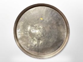 An Eastern engraved brass charger,