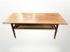 A Danish teak rectangular coffee table with rattan undershelf, 120cm long x 52cm wide x 47cm high.