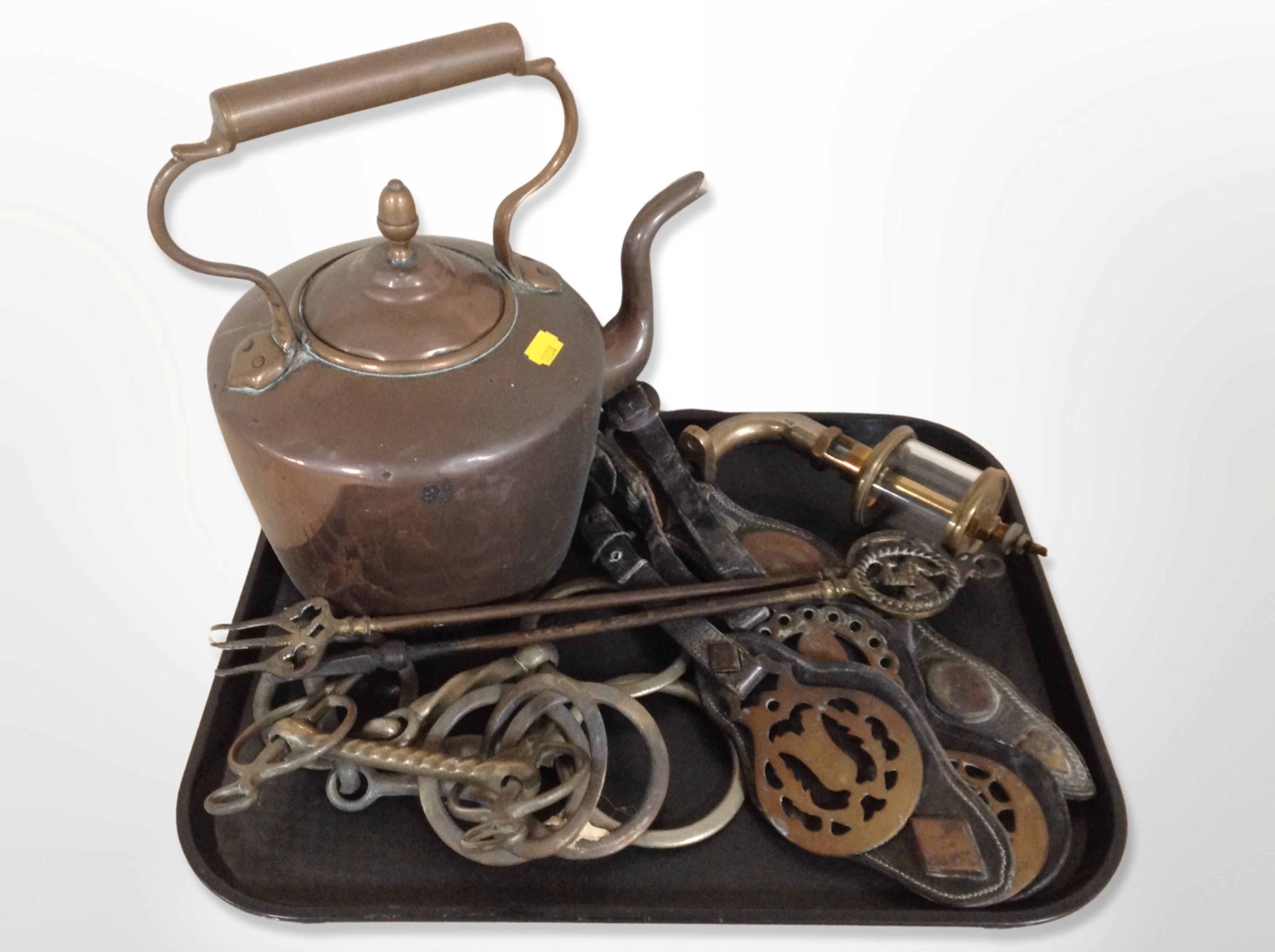 A Victorian copper kettle, together with a quantity of horse brasses on leather straps,
