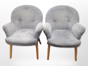 A pair of contemporary armchairs in blue upholstery on tapered wooden legs