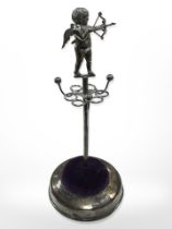 A silver ring stand surmounted by a figure of Cupid, Robert Pringle & Sons, Birmingham 1910,