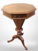 A walnut octagonal work table on carved tripod pedestal,