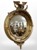 A Regency-style gilt gesso convex porthole mirror, surmounted by an eagle,