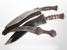 Two Kukri knives in sheathes, and an antique Arab Jambiya knife,