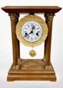 A Dutch teak and gilt metal portico mantel clock, striking on a bell, with pendulum and key,