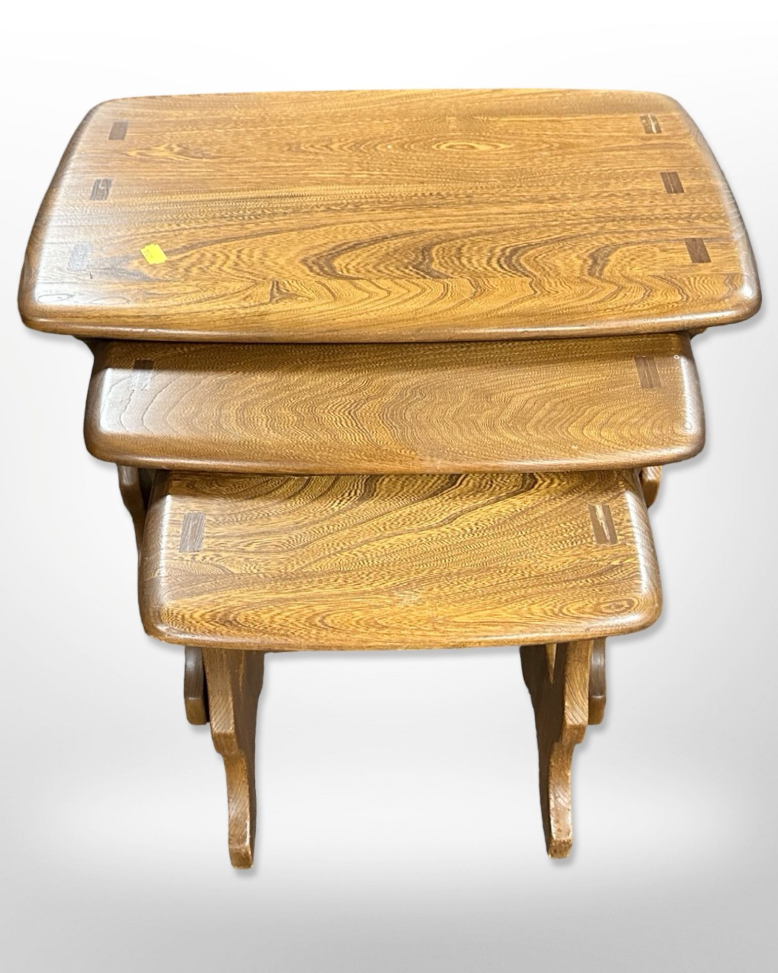 An Ercol stained elm nest of three tables, width 57cm.