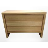 A contemporary oak veneered three-drawer chest,
