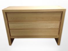 A contemporary oak veneered three-drawer chest,