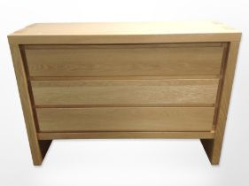 A contemporary oak veneered three-drawer chest,