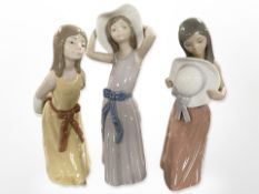 Three Lladró figures of girls wearing summer dresses, tallest 26cm.