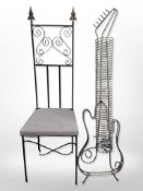 A wrought iron high back chair and a metal CD rack in the form of a guitar,