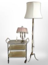 A brass and onyx standard lamp, a further brass table lamp, and a three-tier drinks trolley.