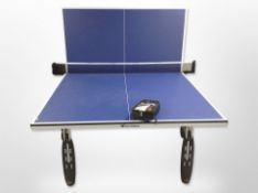 A Cornilleau table tennis table with bats, balls and net,