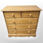 A contemporary pine five drawer chest,