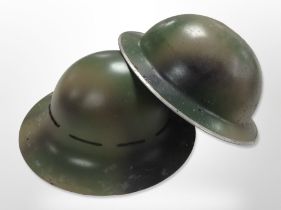 Two 20th-century military helmets.