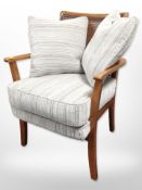 A contemporary bergere armchair in grey striped fabric with cushions