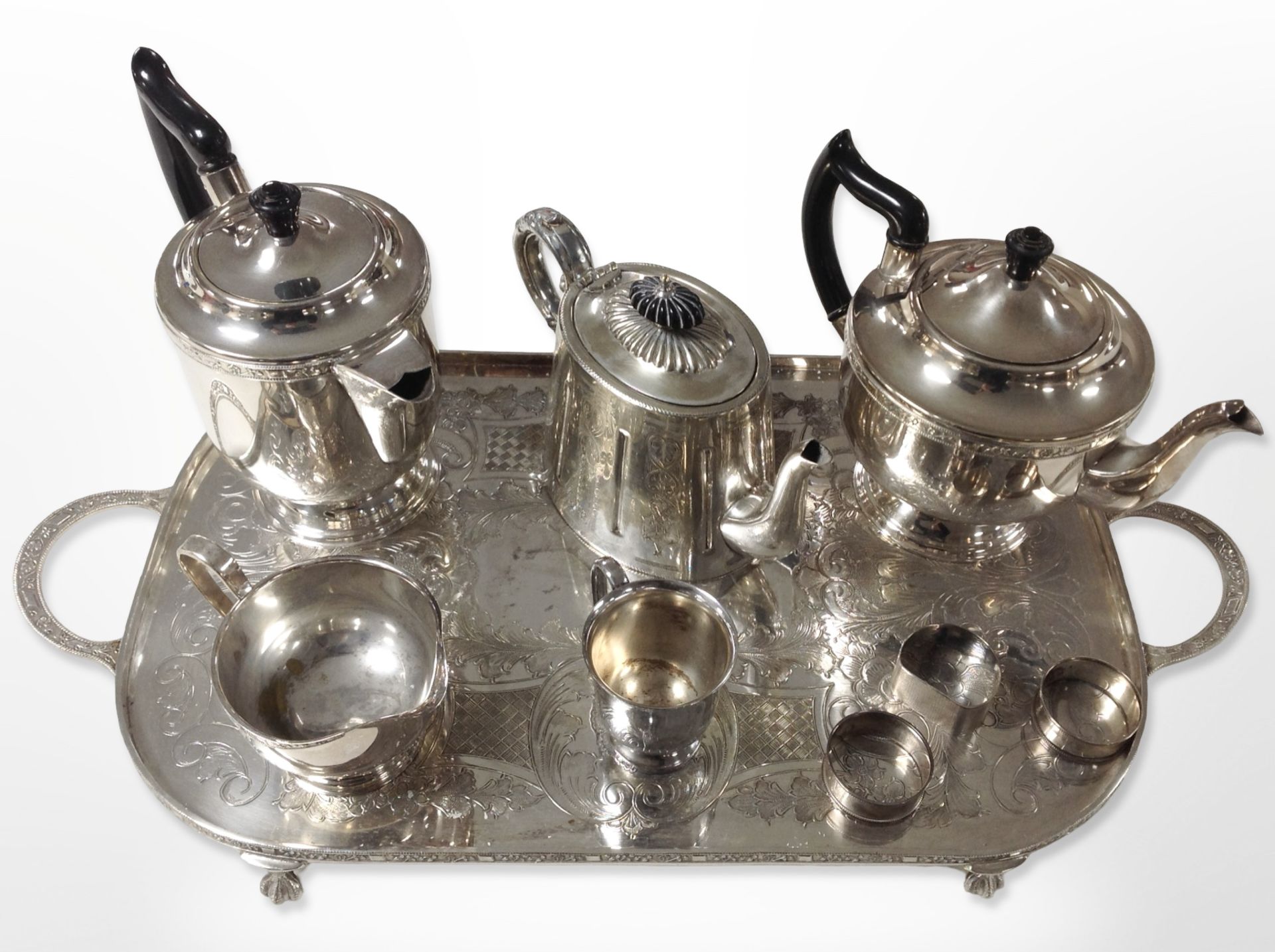 A silver-plated three-piece tea service on etched twin-handled serving tray,
