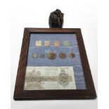 A framed montage of stamps, coins, and a £1 bank note, No.