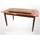 A teak extending dining table with leaf,