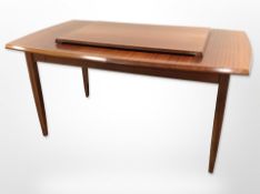 A teak extending dining table with leaf,