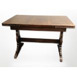 An early-20th century oak pull-out extending dining table,