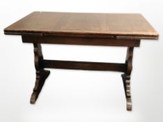 An early-20th century oak pull-out extending dining table,