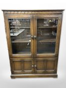 An Ercol stained elm glazed door cabinet,