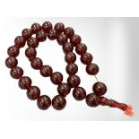 An impressive large cherry amber necklace with thirty three large spherical beads,