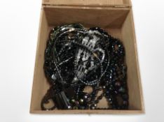 A tea box containing hematite jewellery and Austrian iridescent glass necklaces.