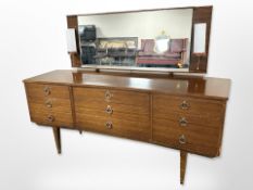 A 20th century teak inverted bow-front mirror back dressing table,